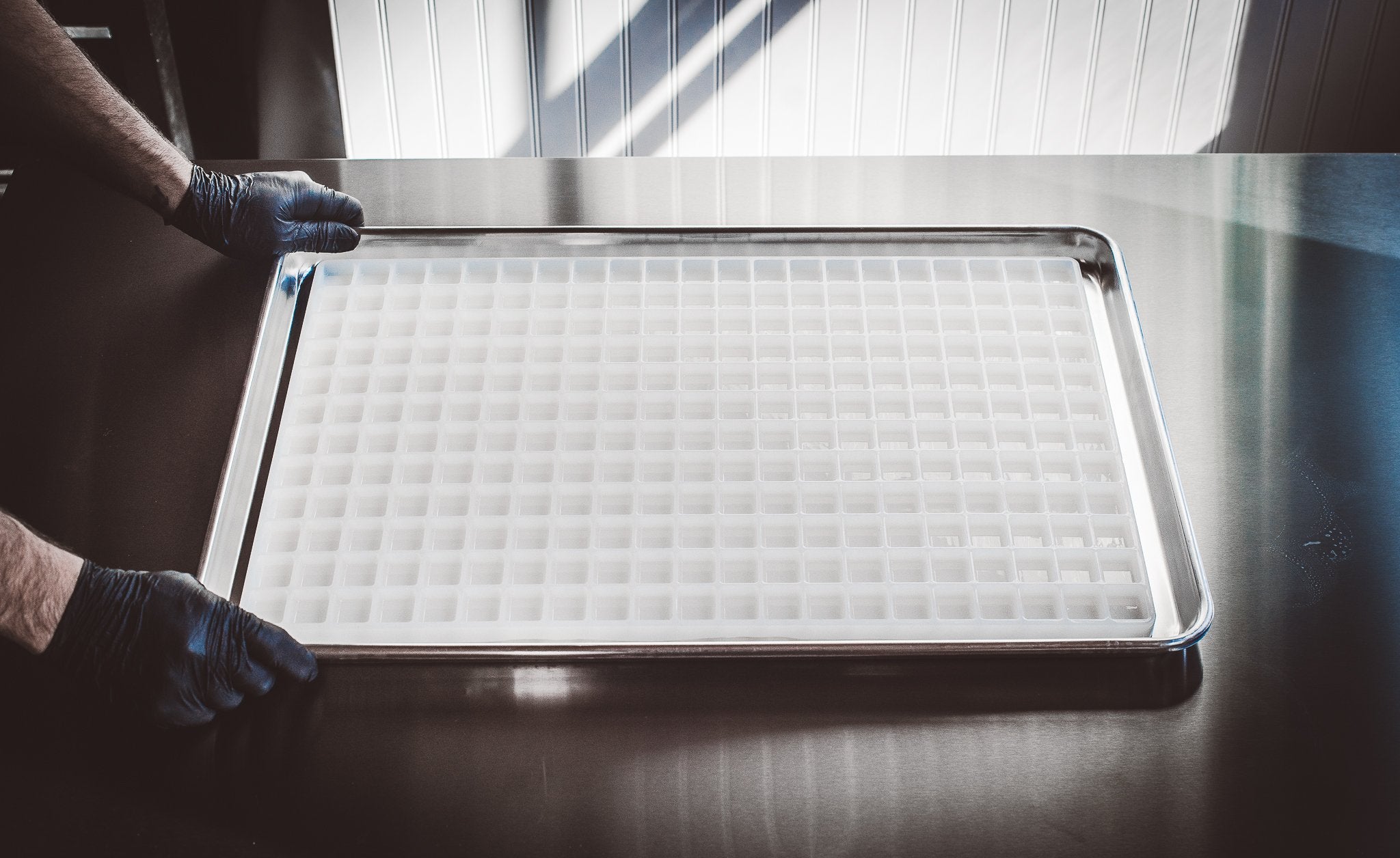 HandsHoldingBakingTrayonKitchenTable6.8mLBarCandyMoldPlain252Cavities100PercentPlatinumSiliconeFullSheet