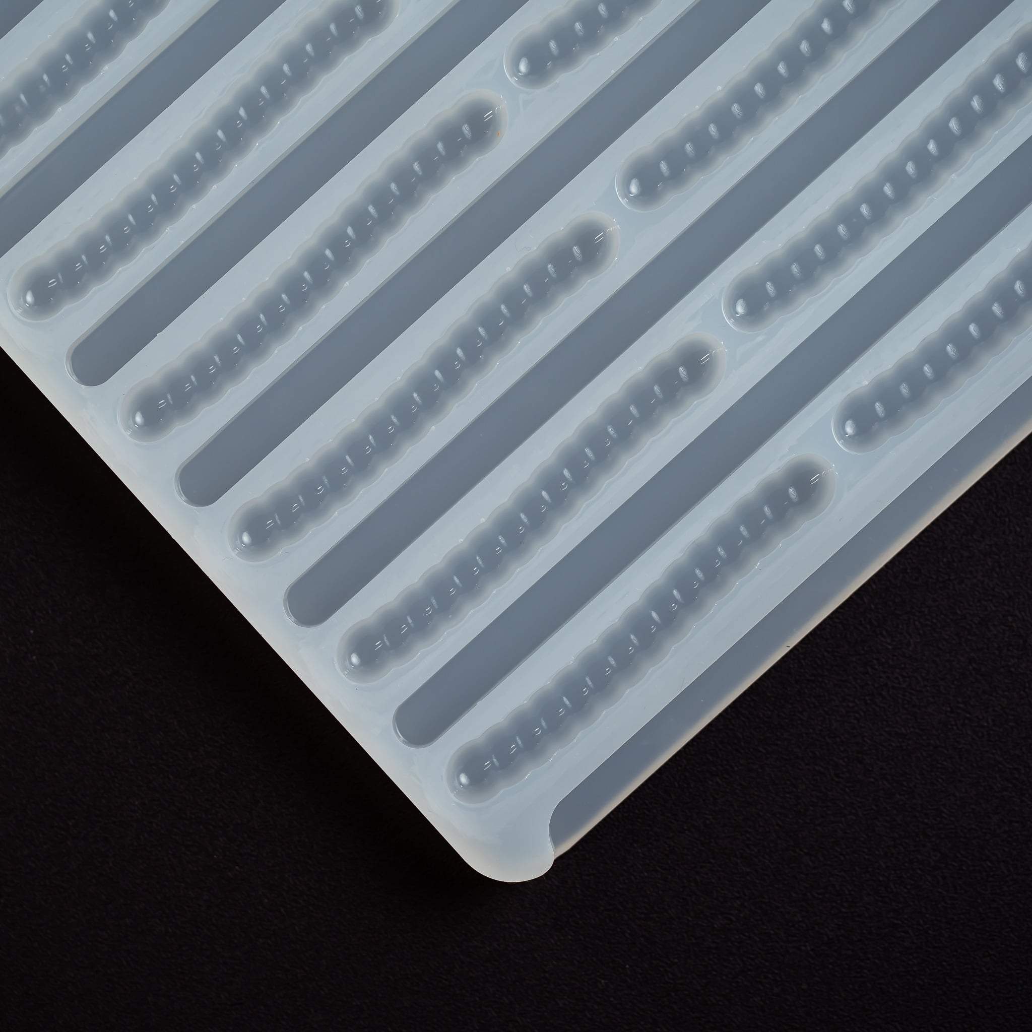 cornercloseup5mLGummyWormDepositorCandyGummyMoldPlain66cavitiesblackgroundtranslucentmold100%platinumsilicone
