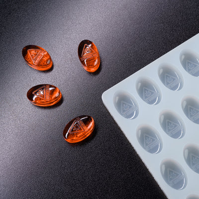 Orange silicone mold on a black surface with a clear silicone mold in the background
