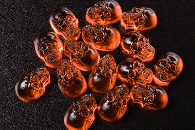 Amber-colored skull-shaped objects on a dark background